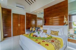 Un dormitorio con una cama tamaño king con una pieza central sobre ella. en Anari Villas Kuta, en Legian