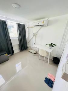 a white room with a table and a window at Tiger Homestay in Bangkok