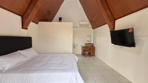 ein Schlafzimmer mit einem Bett und einem Flachbildfernseher in der Unterkunft Teras Alam in Karangjati
