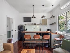 a kitchen and living room with a bar and chairs at Whitehouse Cottage - Margaret River in Margaret River Town +14 photos