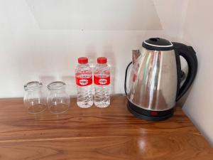 ein Teekessel und vier Flaschen Wasser auf einem Tisch in der Unterkunft Teras Alam in Karangjati + 7 Fotos
