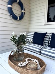 a table with a vase of flowers and a basket of eggs at The Chill - Your Dreamy Waterfront Escape in Sanctuary Point