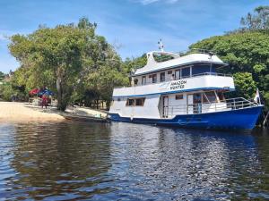 een grote boot is aangemeerd op het water bij Iate AmazonHunter in Manaus