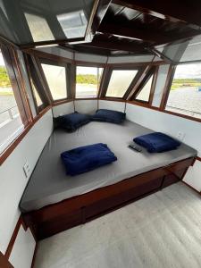 een bed in het midden van een boot met blauwe kussens bij Iate AmazonHunter in Manaus