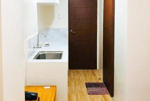 a kitchen with a sink and a wooden floor at Avelida Homes by RedDoorz in Iloilo City