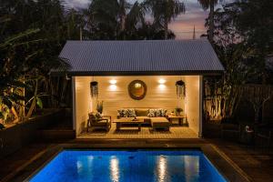a swimming pool in front of a house with a couch at Luxury Family Estate l Pool & Pet Friendly l Nova Escapes in Bangalow