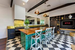 a kitchen with a counter with stools around it at Luxury Family Estate l Pet Friendly l Nova Escapes in Bangalow