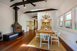 a dining room with a table and a fireplace at Luxury Family Estate l Pool & Pet Friendly l Nova Escapes in Bangalow