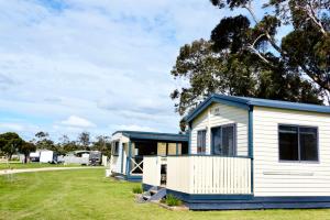 a blue and white tiny house in a field at BIG4 Long Jetty Caravan Park in Port Welshpool