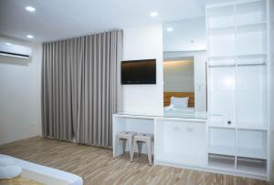 a room with a vanity with two stools and a mirror at Avelida Homes by RedDoorz in Iloilo City