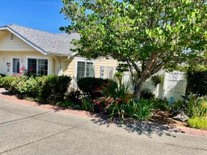 a house with a tree and flowers in front of it at Warm and Inviting in Grants Pass