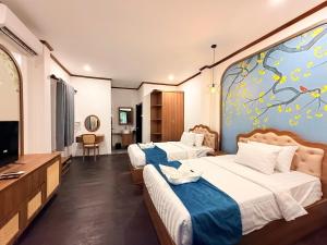 una camera d'albergo con due letti e una tv di Vangvieng Night Market Resort a Vang Vieng