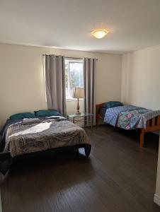 a bedroom with two beds and a window at Modern 3BR Home Near Niagara Falls & Welland Canal in Welland