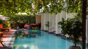 ein Schwimmbad in einem Gebäude mit Bäumen und Pflanzen in der Unterkunft FCC Angkor by Avani in Siem Reap