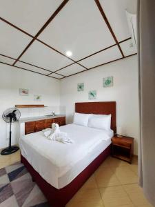 a bedroom with a large white bed with white sheets at Sunville Hotel and Restaurant in Panglao