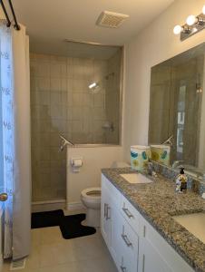a bathroom with two sinks and a toilet and a mirror at Modern 3BR Home Near Niagara Falls & Welland Canal in Welland