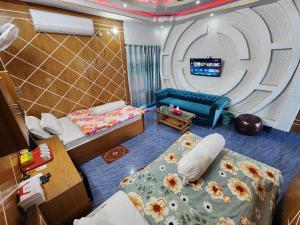 a room with two beds and a couch and a tv at Mukta Nagar Resort in Pitua