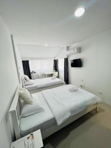 a bedroom with two beds with white sheets at Tiger Homestay in Bangkok +29 photos