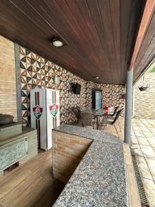 a patio with a refrigerator and a table with chairs at Casa Moderna com piscina e churrasqueira in Rio de Janeiro
