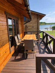 a wooden deck with a table and chairs on a cabin at Берег Світязя 3 in Svityazʼ