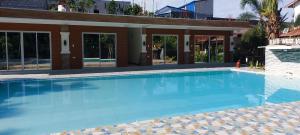 a large blue swimming pool in front of a building at KNB West Villa Inn by SMS Hospitality in Bolinao