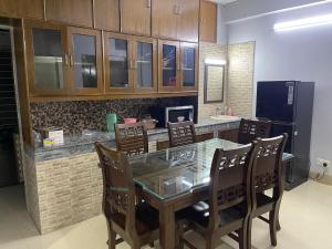 a dining room with a glass table and chairs at Bashundhara Luxury 3BR Apartment Near Evercare in Dhaka