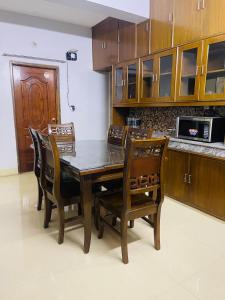 a kitchen with a wooden table and chairs at Bashundhara Luxury 3BR Apartment Near Evercare in Dhaka