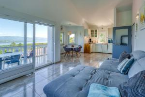 a living room with a blue couch and a balcony at Holiday house Anita in Šilo