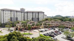 un grande edificio con auto parcheggiate in un parcheggio di Homestay Putrajaya Milmot a Gua Sai