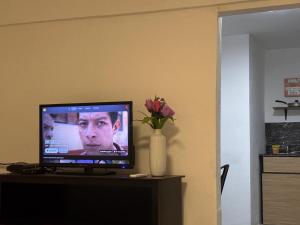 a television sitting on a table with a vase of flowers at Casa María Fernanda #2 in Matamoros