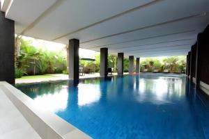 a swimming pool in a house with blue water at Mitra Bandung Hotel in Bandung