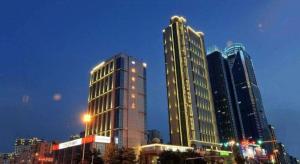 a group of tall buildings in a city at night at Qingdao Haidu Hotel in Huangdao