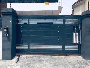 Sagisaにある5bedroom duplexの建物のゲートが付いた緑色のガレージドア