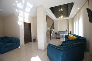 a living room with two blue couches and a staircase at Golden Nugget Tbilisi in Tbilisi City