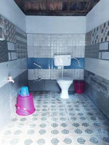 Un baño con inodoro y cubos dentro. en EarthWise Camping, en Kalpetta