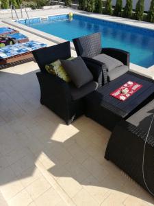- une terrasse avec 2 chaises et une table à côté de la piscine dans l'établissement Apartments Jankovic, à Vodice