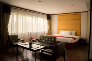 une chambre d'hôtel avec un lit, une table et des chaises dans l'établissement Horizon Hotel, à Olongapo
