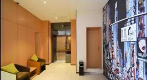 a lobby of a building with a sign on the wall at IU Hotel Zhengzhou Xinzheng Sias International University Branch in Zhengzhou