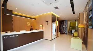 a lobby of a building with a woman sitting at a counter at IU Hotel Zhengzhou Xinzheng Sias International University Branch in Zhengzhou