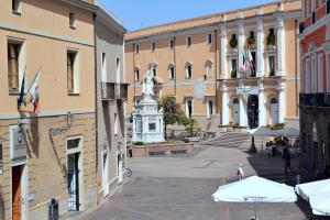 a city street with buildings and a statue in the middle at Eleonora Room & Breakfast in Oristano