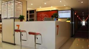 a counter with two red stools in a restaurant at 7 Days Premium Jingjiang Fuhai New World Automobile Terminal Branch in Jingjiang