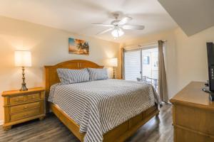 a bedroom with a bed and a ceiling fan at Tybee Summer Winds 523 Condo in Tybee Island +25 photos