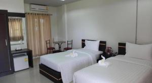 Dos camas en una habitación de hotel con sábanas blancas. en Baan Ing Daan, en Amnat Charoen 74 fotos más