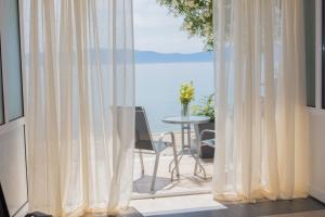 a view of the ocean from a balcony with curtains at Villa Orca in Podaca