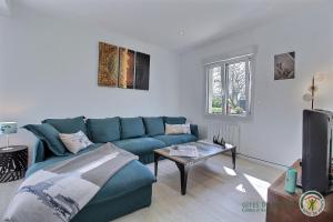 a living room with a blue couch and a tv at Ker wan in Plérin
