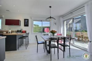 Una cocina y un comedor con mesa y sillas. en Ker wan, en Plérin 17 fotos más