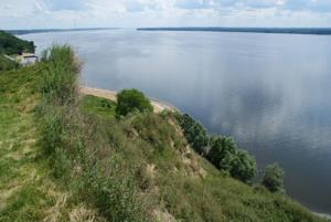 a grassy hill with a view of a body of water at Pod Zachrypniętym Kogutem in Glewo +4 photos