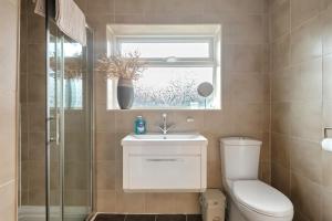 a bathroom with a toilet and a sink and a window at Awesome Games Room House! EMA Donington Park, with FREE parking in Kegworth +18 photos