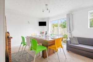 a dining room with a table with chairs and a couch at Awesome Games Room House! EMA Donington Park, with FREE parking in Kegworth