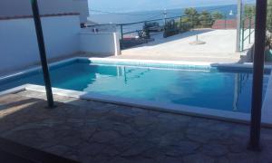 a swimming pool in a house with blue water at Apartments Laguna in Stomorska